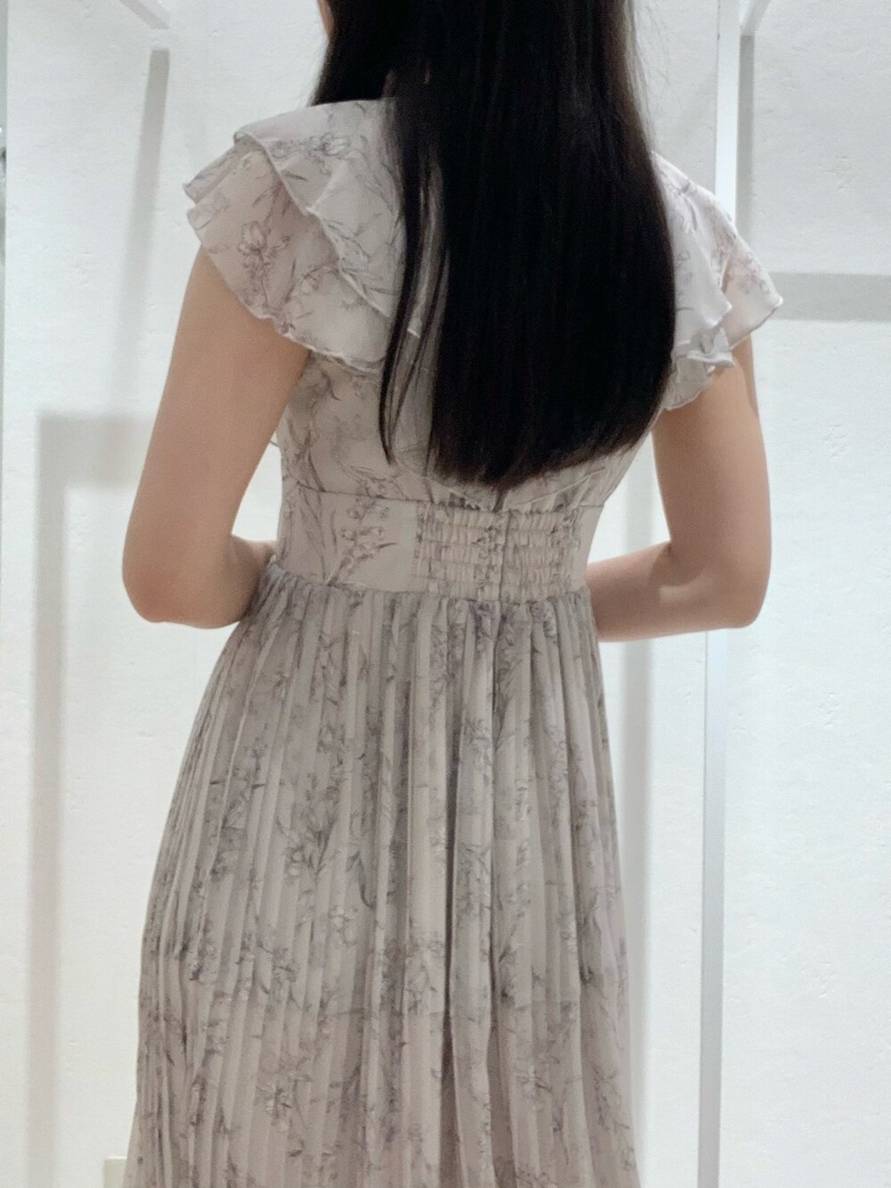 ベージュ系のショルダーバッグ、ピンク系のワンピース、ホワイト系のカーディガン/ボレロを着用したレディースの春コーディネートの5枚目の写真