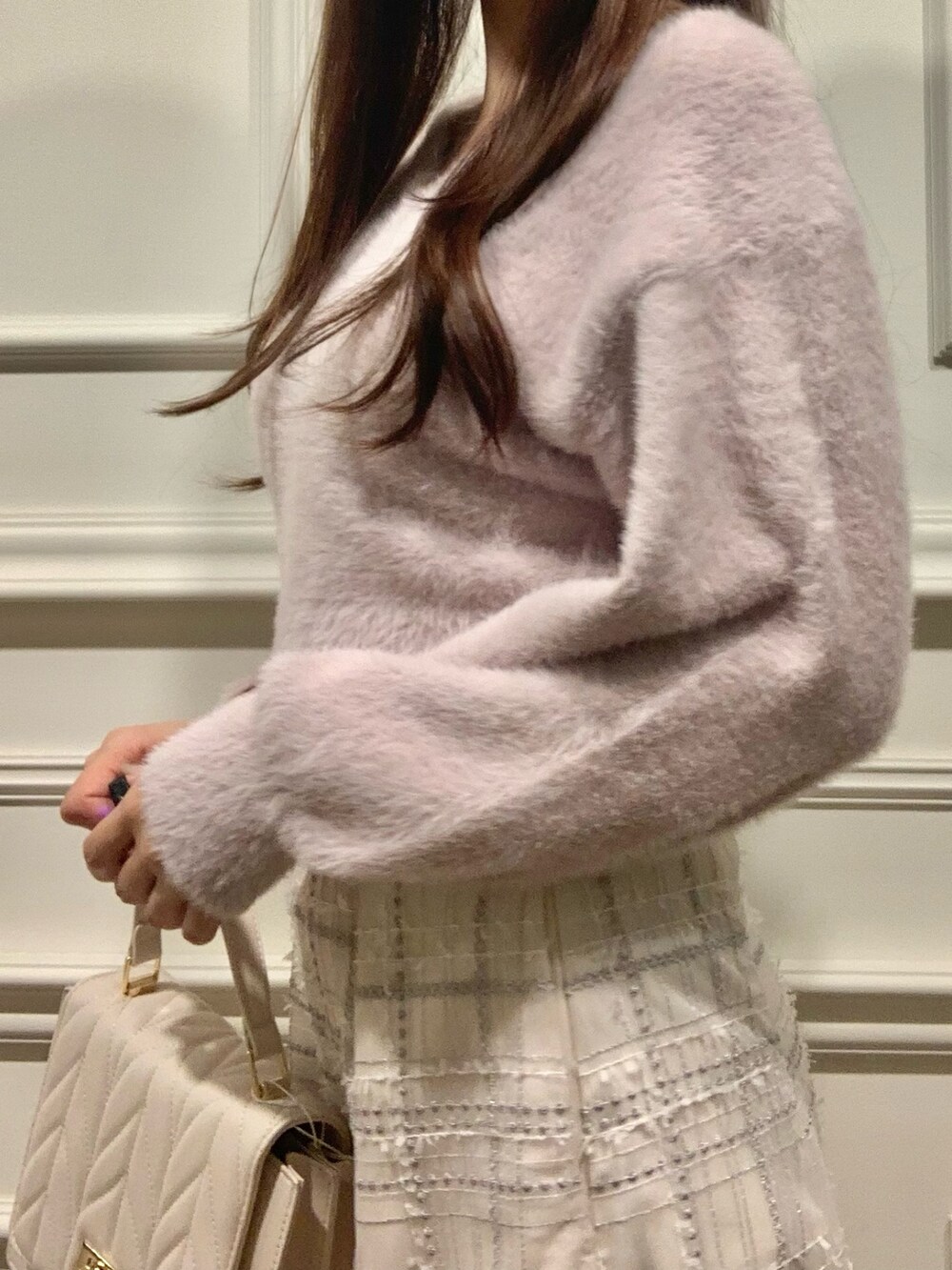 ホワイト系のスカート、ホワイト系のショルダーバッグ、ピンク系のニット/セーターを着用したレディースの秋コーディネートの4枚目の写真