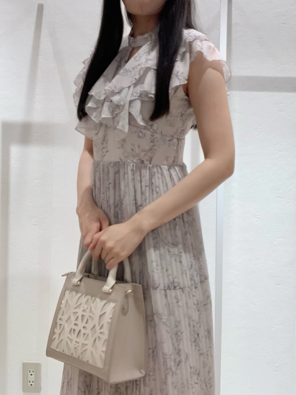 ベージュ系のショルダーバッグ、ピンク系のワンピース、ホワイト系のカーディガン/ボレロを着用したレディースの春コーディネートの4枚目の写真