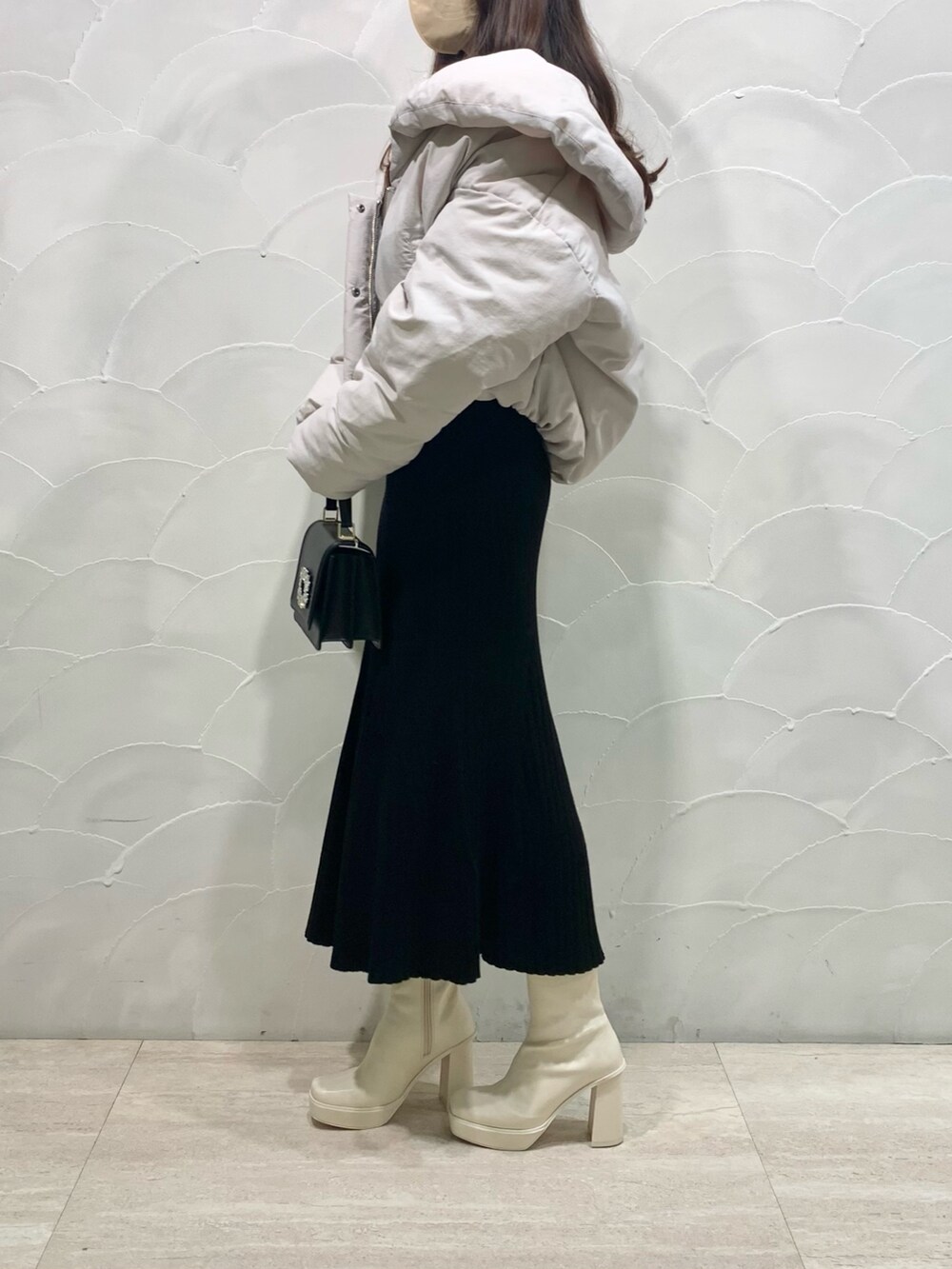 ホワイト系のダウンジャケット/コート、ブラック系のショルダーバッグ、ホワイト系のブーツを着用したレディースの冬コーディネートの2枚目の写真