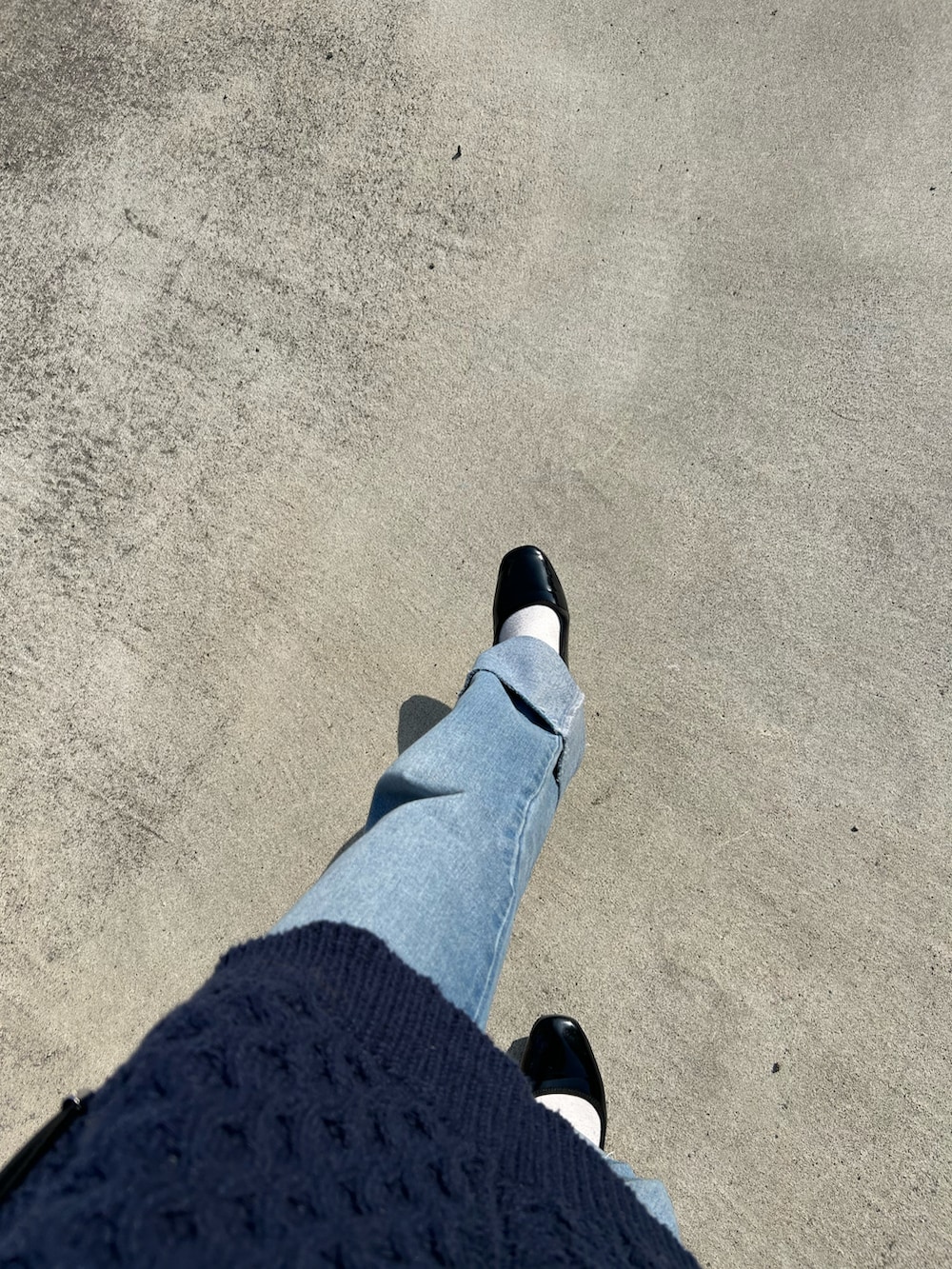 ブルー系のデニムパンツ、ブラック系のバレエシューズ、ブルー系のニット/セーターを着用したレディースの秋コーディネートの2枚目の写真