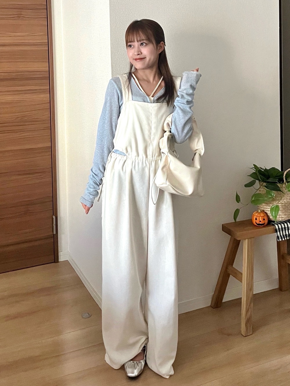 ホワイト系のハンドバッグ、ブルー系のTシャツ/カットソー、ホワイト系のサロペット/オーバーオールを着用したレディースの秋コーディネートの3枚目の写真