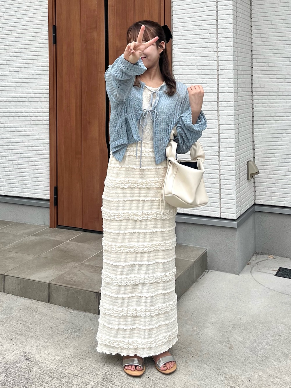 ブルー系のカーディガン/ボレロ、ホワイト系のスカート、ホワイト系のハンドバッグを着用したレディースの夏コーディネートの2枚目の写真