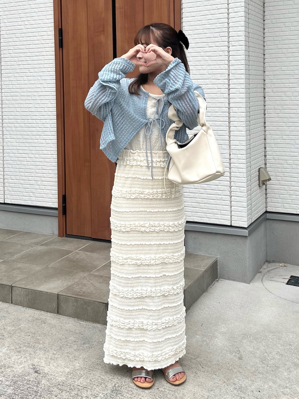 ブルー系のカーディガン/ボレロ、ホワイト系のスカート、ホワイト系のハンドバッグを着用したレディースの夏コーディネートの3枚目の写真