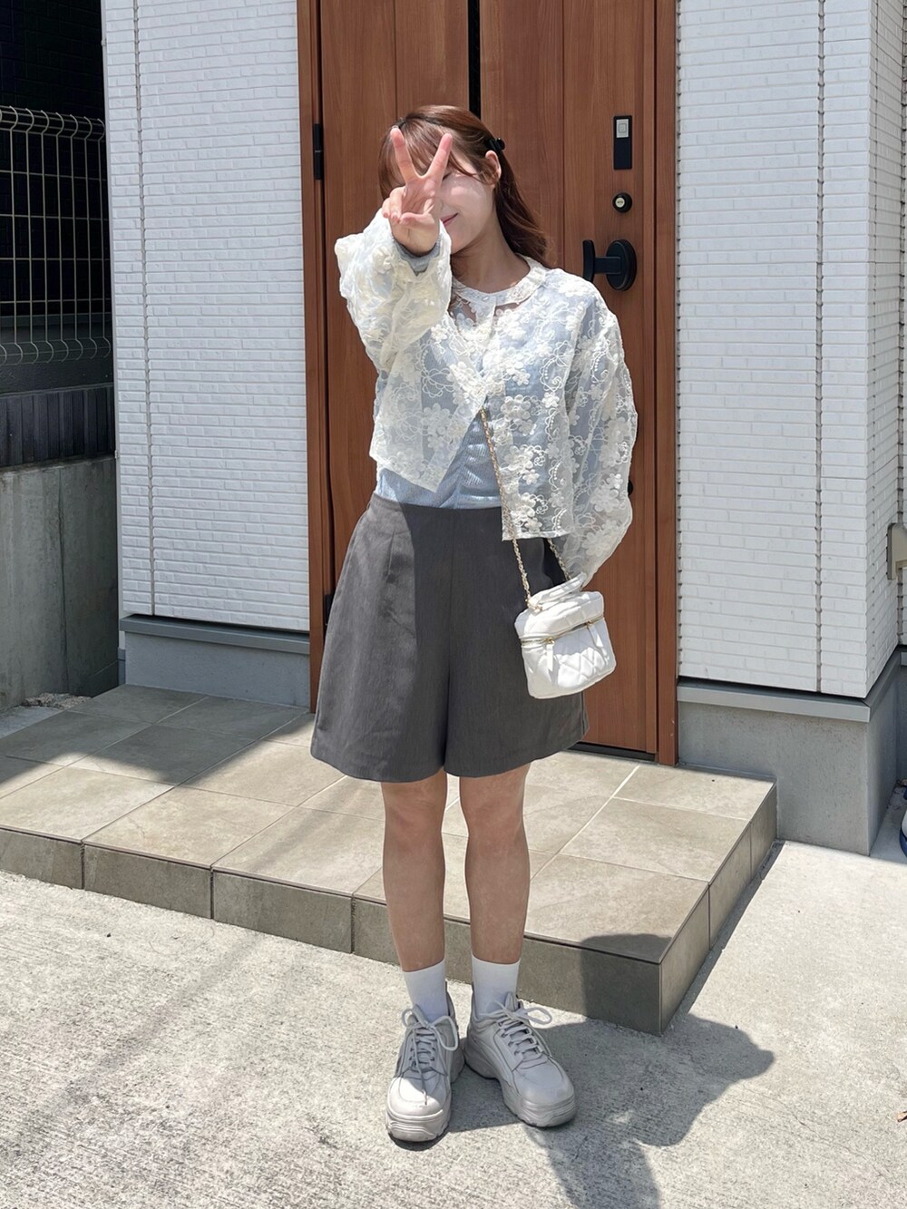 グレー系のその他パンツ、ホワイト系のバッグ、ホワイト系のシューズを着用したレディースの夏コーディネートの2枚目の写真