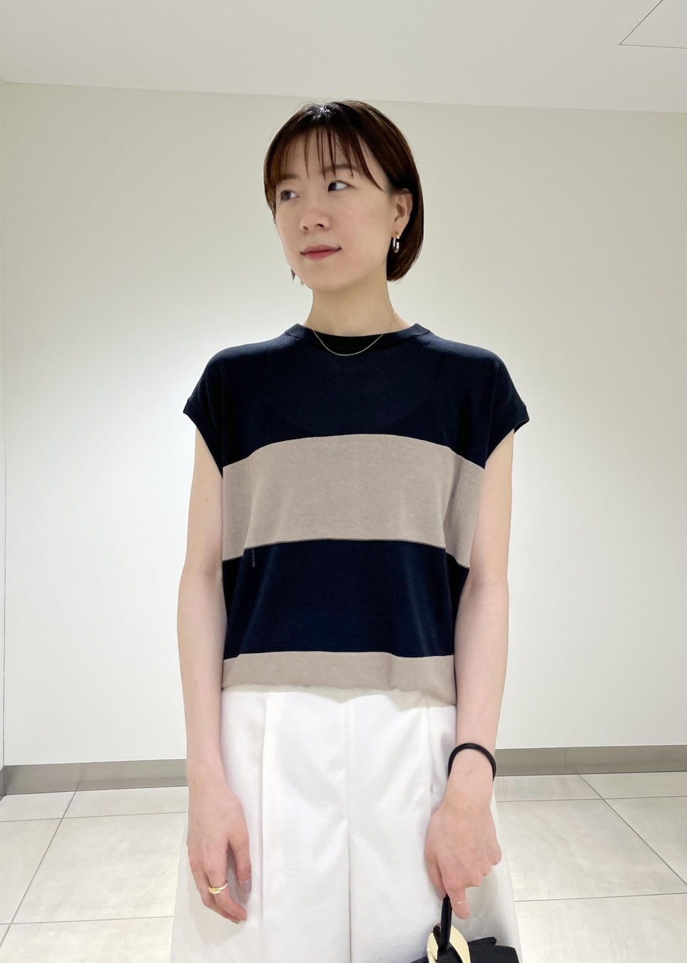 ブラック系のハンドバッグ、ブラック系のサンダル、ホワイト系のその他パンツを着用したレディースの夏コーディネートの3枚目の写真