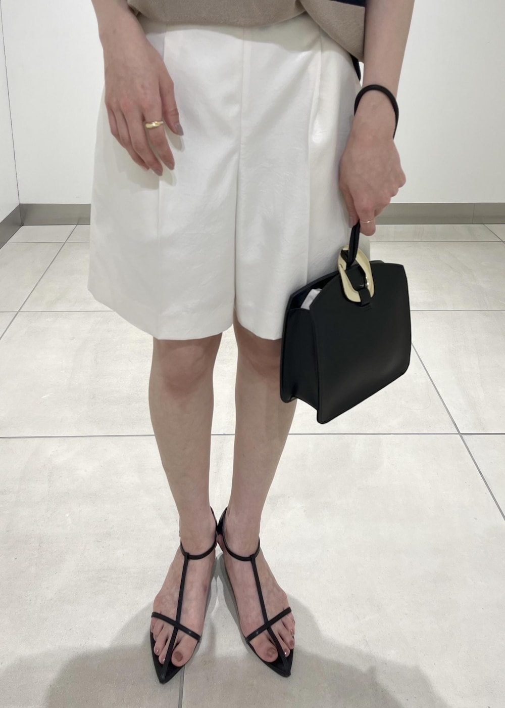 ブラック系のハンドバッグ、ブラック系のサンダル、ホワイト系のその他パンツを着用したレディースの夏コーディネートの4枚目の写真