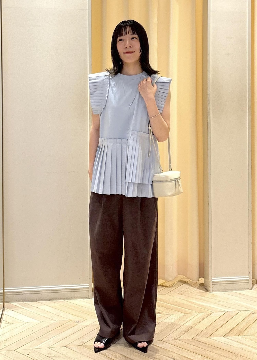 ブラック系のサンダル、ブルー系のTシャツ/カットソー、ホワイト系のショルダーバッグを着用したレディースの夏コーディネートの2枚目の写真