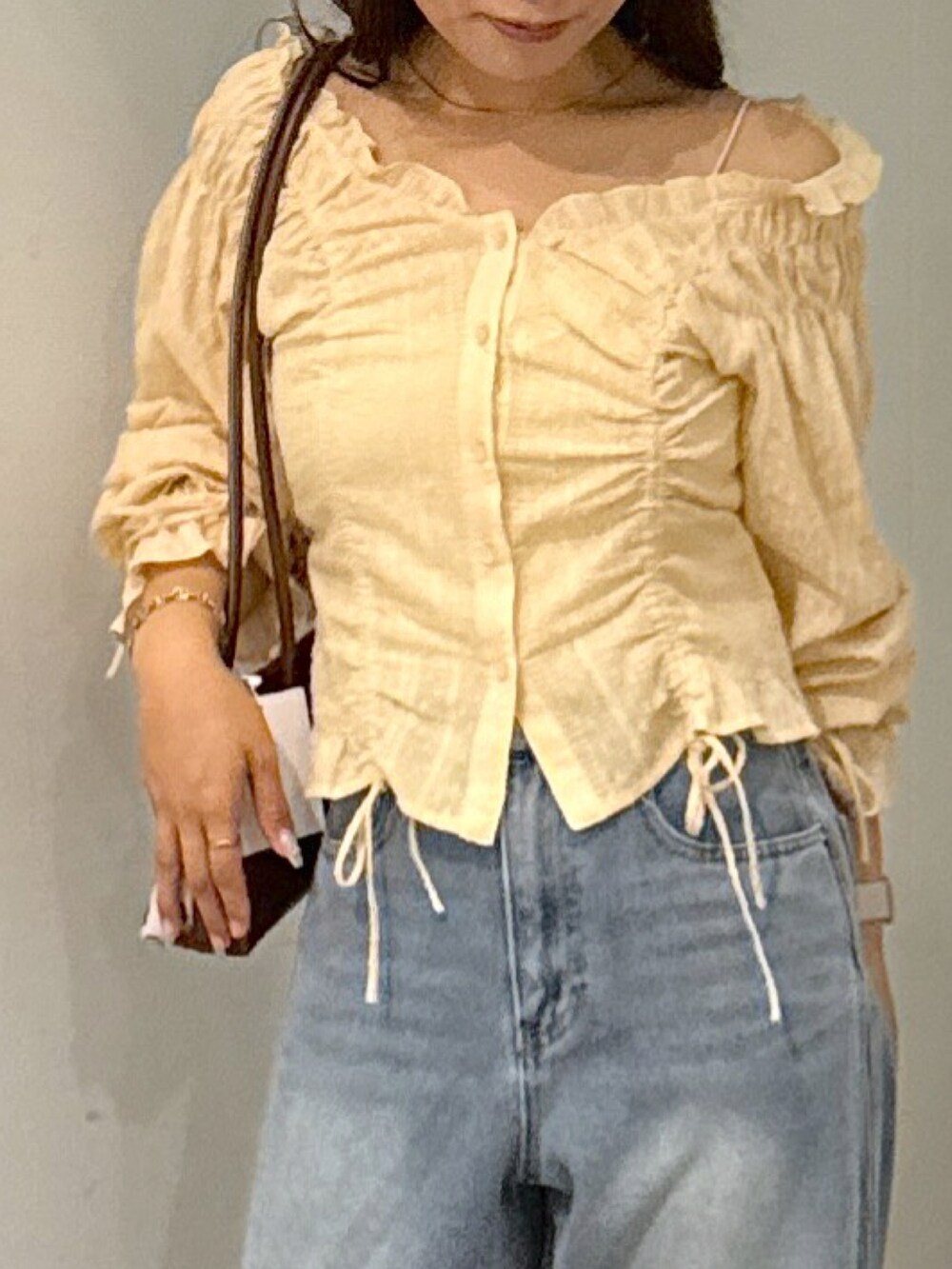 ホワイト系のキャミソール、ブラウン系のショルダーバッグ、イエロー系のシャツ/ブラウスを着用したレディースの秋コーディネートの4枚目の写真