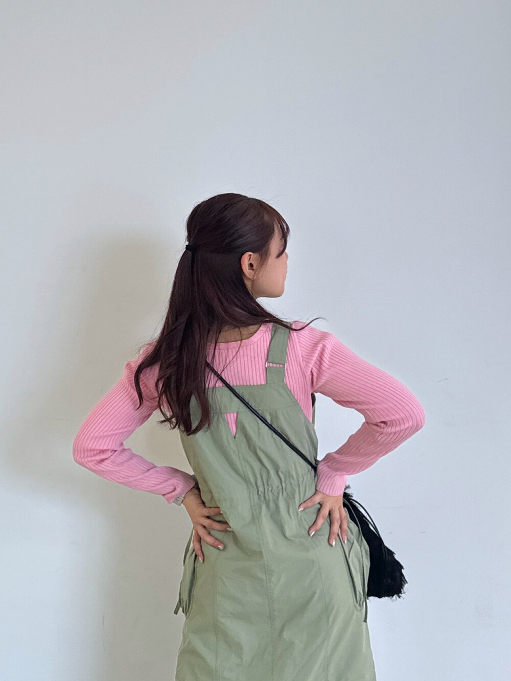 ブラック系のハンドバッグ、ブラック系のサンダル、ピンク系のニット/セーターを着用したレディースの春コーディネートの4枚目の写真