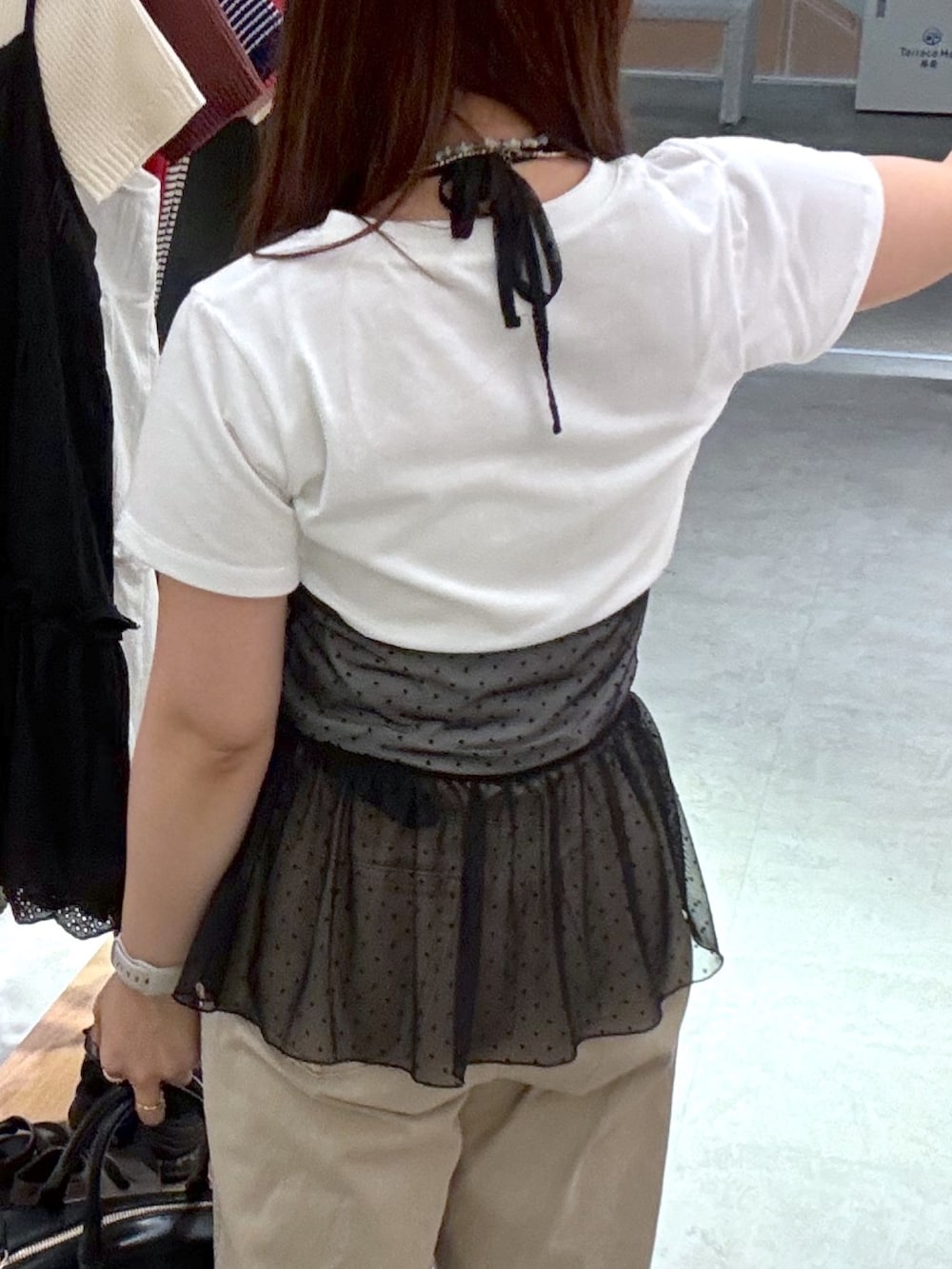 ベージュ系のデニムパンツ、ブラック系のパンプス、ブラック系のハンドバッグを着用したレディースの夏コーディネートの5枚目の写真