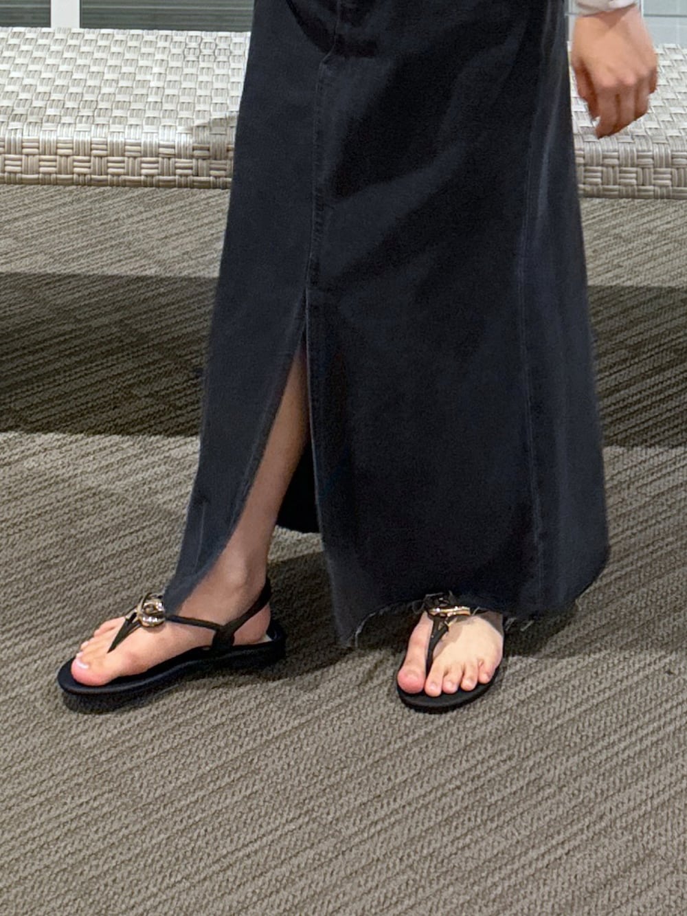 ホワイト系のポロシャツ、ブラック系のショルダーバッグ、ブラック系のデニムスカートを着用したレディースの春コーディネートの5枚目の写真