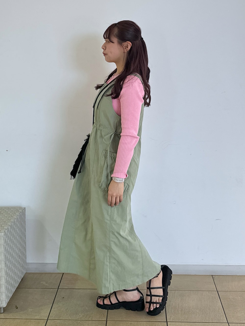 ブラック系のハンドバッグ、ブラック系のサンダル、ピンク系のニット/セーターを着用したレディースの春コーディネートの2枚目の写真