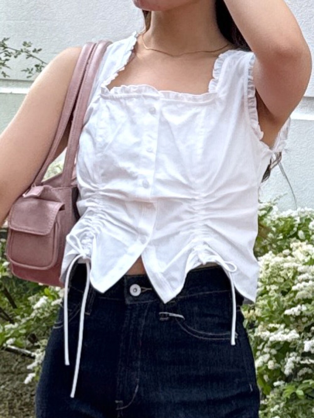 ホワイト系のシャツ/ブラウス、ピンク系のショルダーバッグ、ブルー系のデニムパンツを着用したレディースの夏コーディネートの3枚目の写真