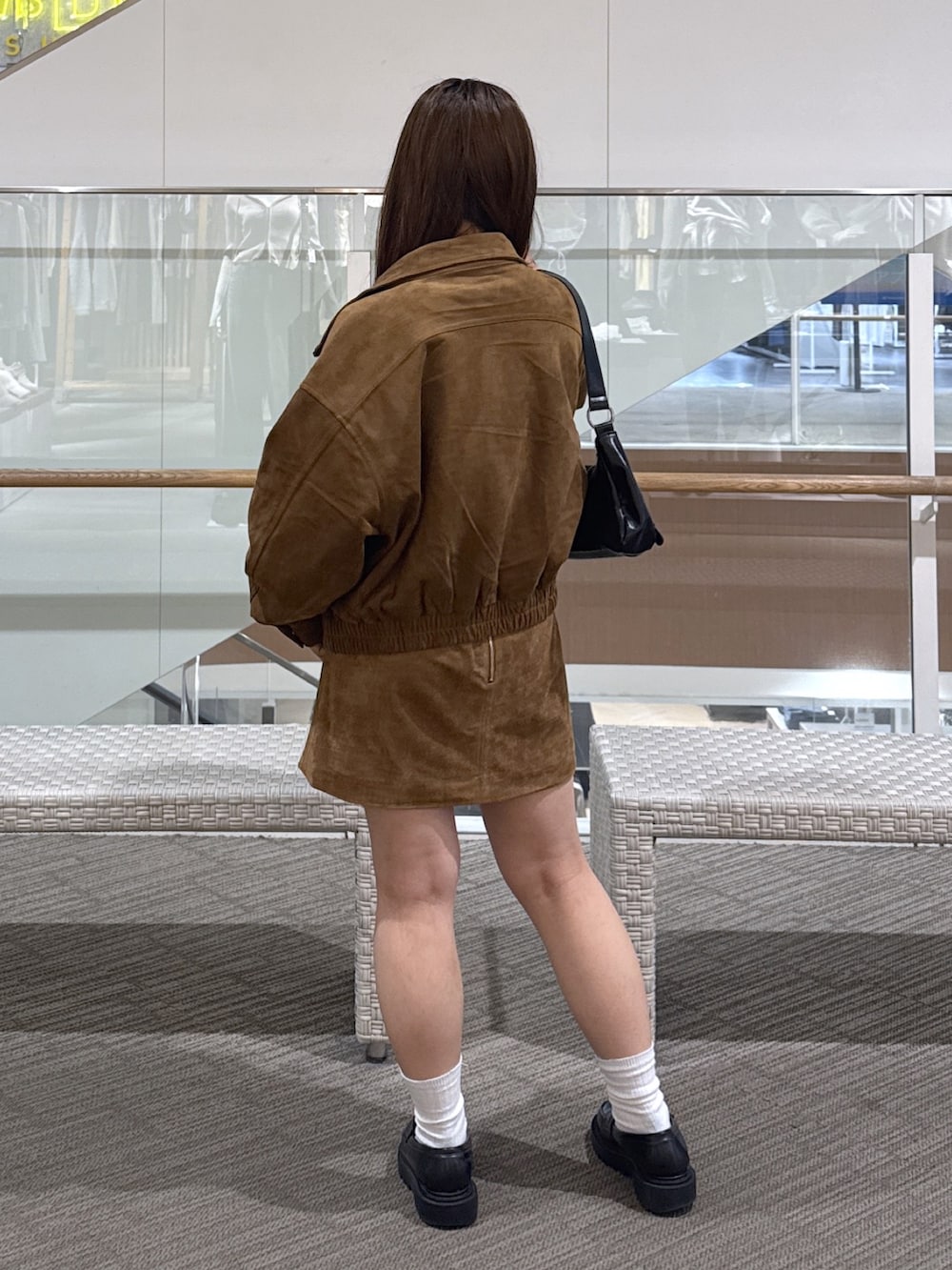 ホワイト系のニット/セーター、ベージュ系のスカート、ブラウン系のブルゾンを着用したレディースの秋コーディネートの4枚目の写真