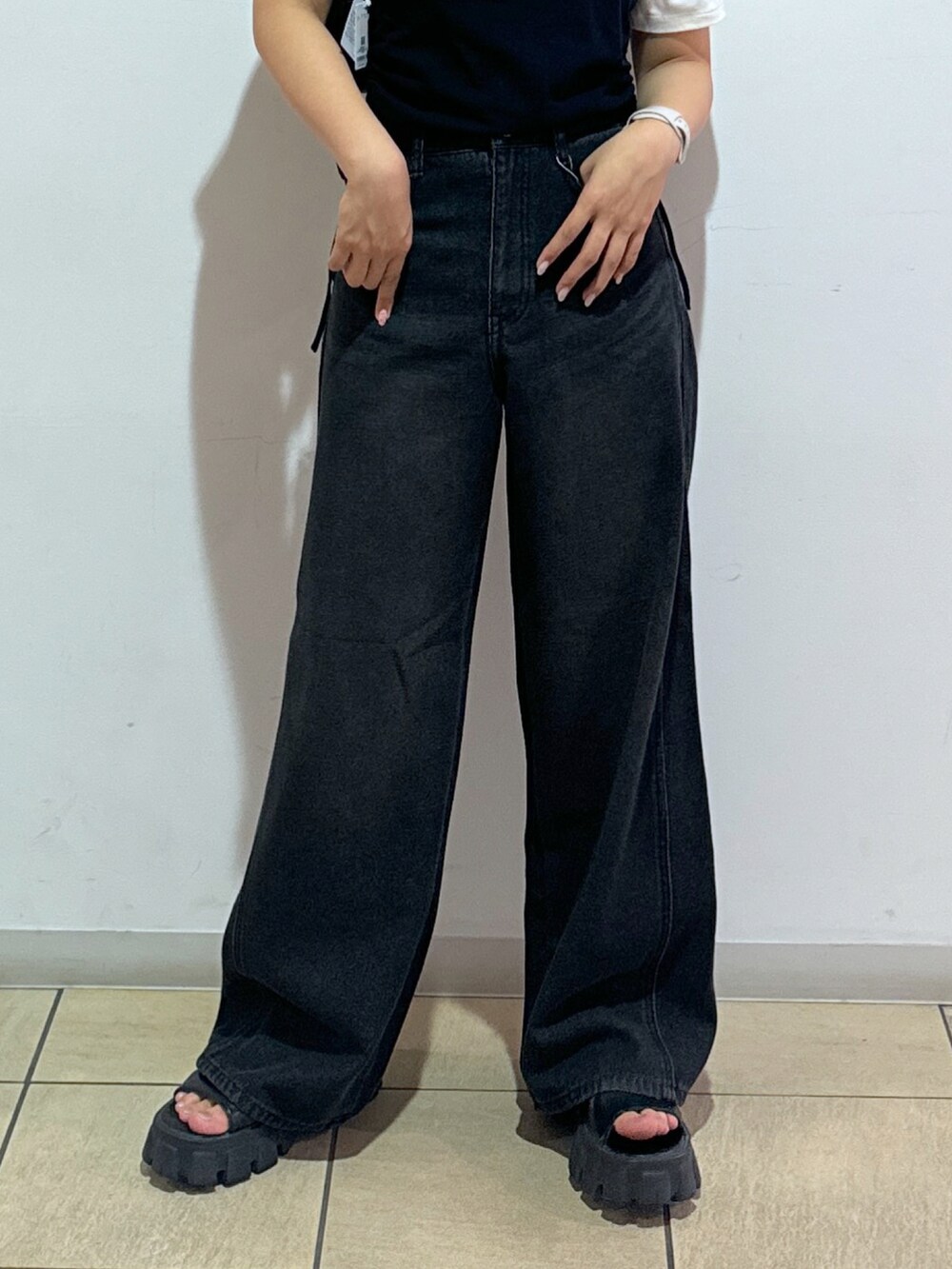 ブルー系のデニムパンツ、ブラック系のトートバッグ、レッド系のTシャツ/カットソーを着用したレディースの夏コーディネートの5枚目の写真