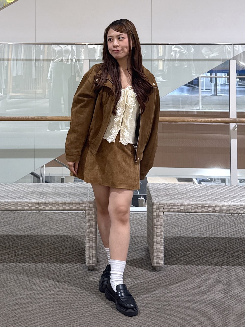 ホワイト系のニット/セーター、ベージュ系のスカート、ブラウン系のブルゾンを着用したレディースの秋コーディネートの2枚目の写真