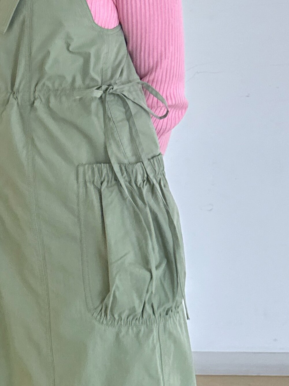 ブラック系のハンドバッグ、ブラック系のサンダル、ピンク系のニット/セーターを着用したレディースの春コーディネートの3枚目の写真