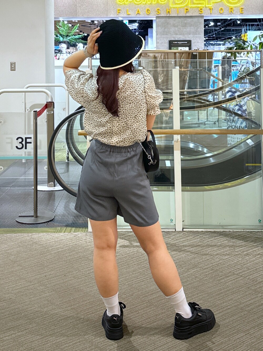 ピンク系のショルダーバッグ、グレー系のスカート、ホワイト系のスニーカーを着用したレディースの春コーディネートの3枚目の写真