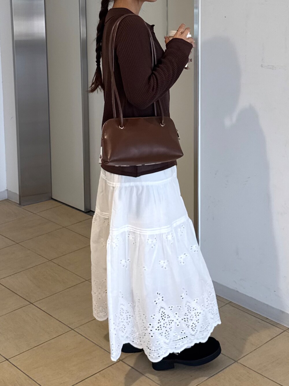 ブラウン系のサンダル、ホワイト系のスカート、ブラウン系のニット/セーターを着用したレディースの秋コーディネートの3枚目の写真