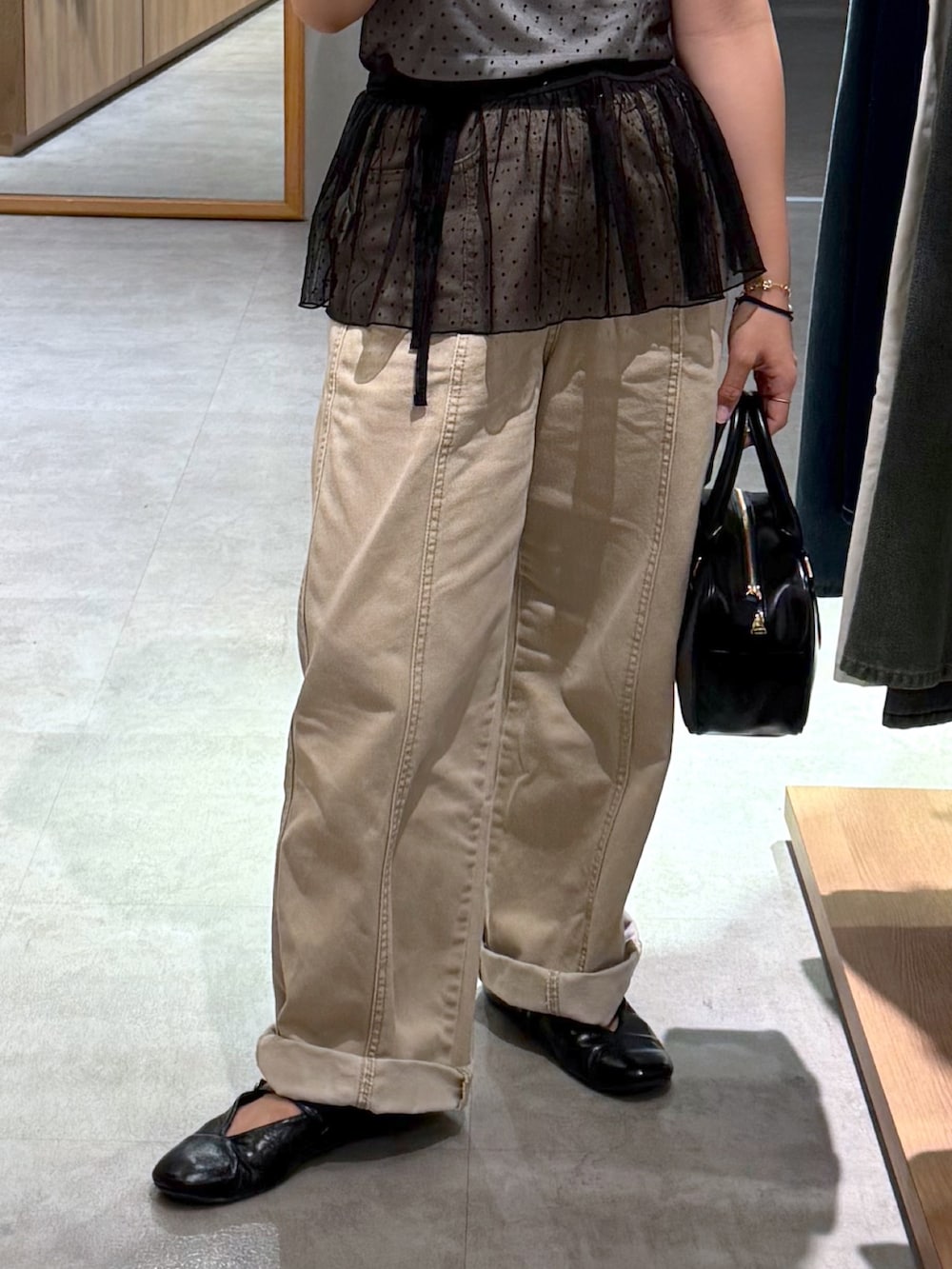 ベージュ系のデニムパンツ、ブラック系のパンプス、ブラック系のハンドバッグを着用したレディースの夏コーディネートの3枚目の写真