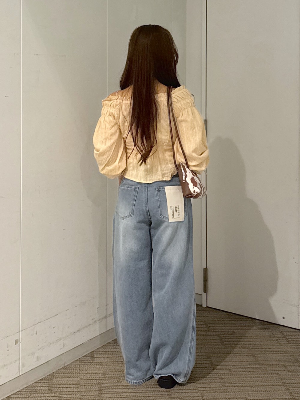 ホワイト系のキャミソール、ブラウン系のショルダーバッグ、イエロー系のシャツ/ブラウスを着用したレディースの秋コーディネートの3枚目の写真