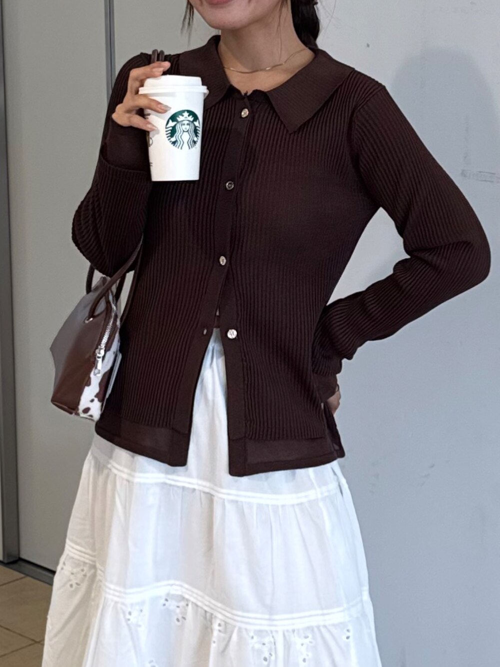 ブラウン系のサンダル、ホワイト系のスカート、ブラウン系のニット/セーターを着用したレディースの秋コーディネートの4枚目の写真