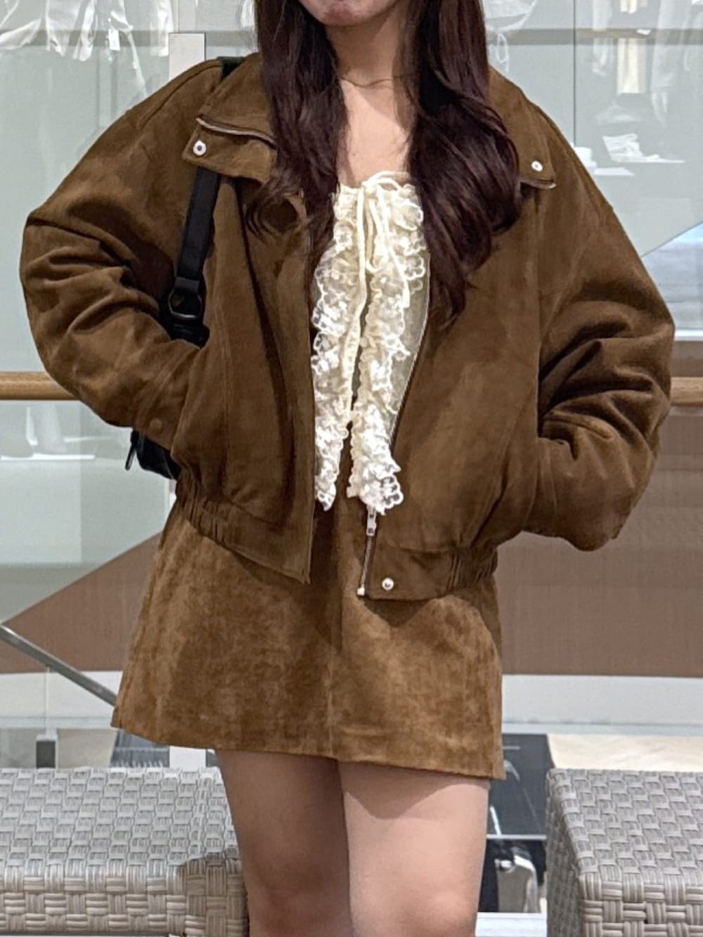 ホワイト系のニット/セーター、ベージュ系のスカート、ブラウン系のブルゾンを着用したレディースの秋コーディネートの5枚目の写真