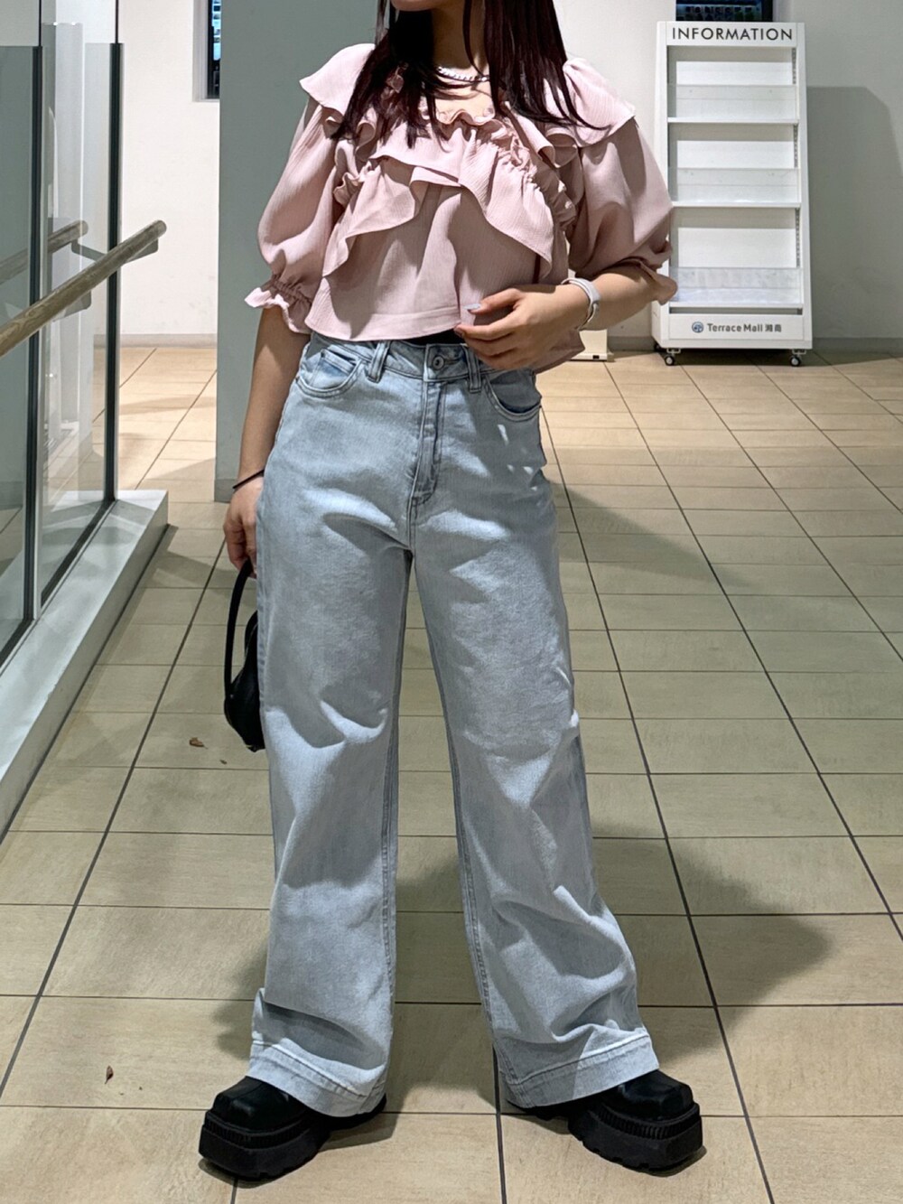 ピンク系のショルダーバッグ、ピンク系のシャツ/ブラウス、ホワイト系のデニムパンツを着用したレディースの春コーディネートの4枚目の写真