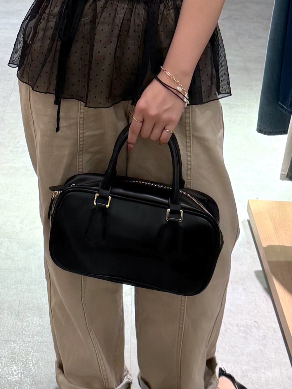 ベージュ系のデニムパンツ、ブラック系のパンプス、ブラック系のハンドバッグを着用したレディースの夏コーディネートの4枚目の写真