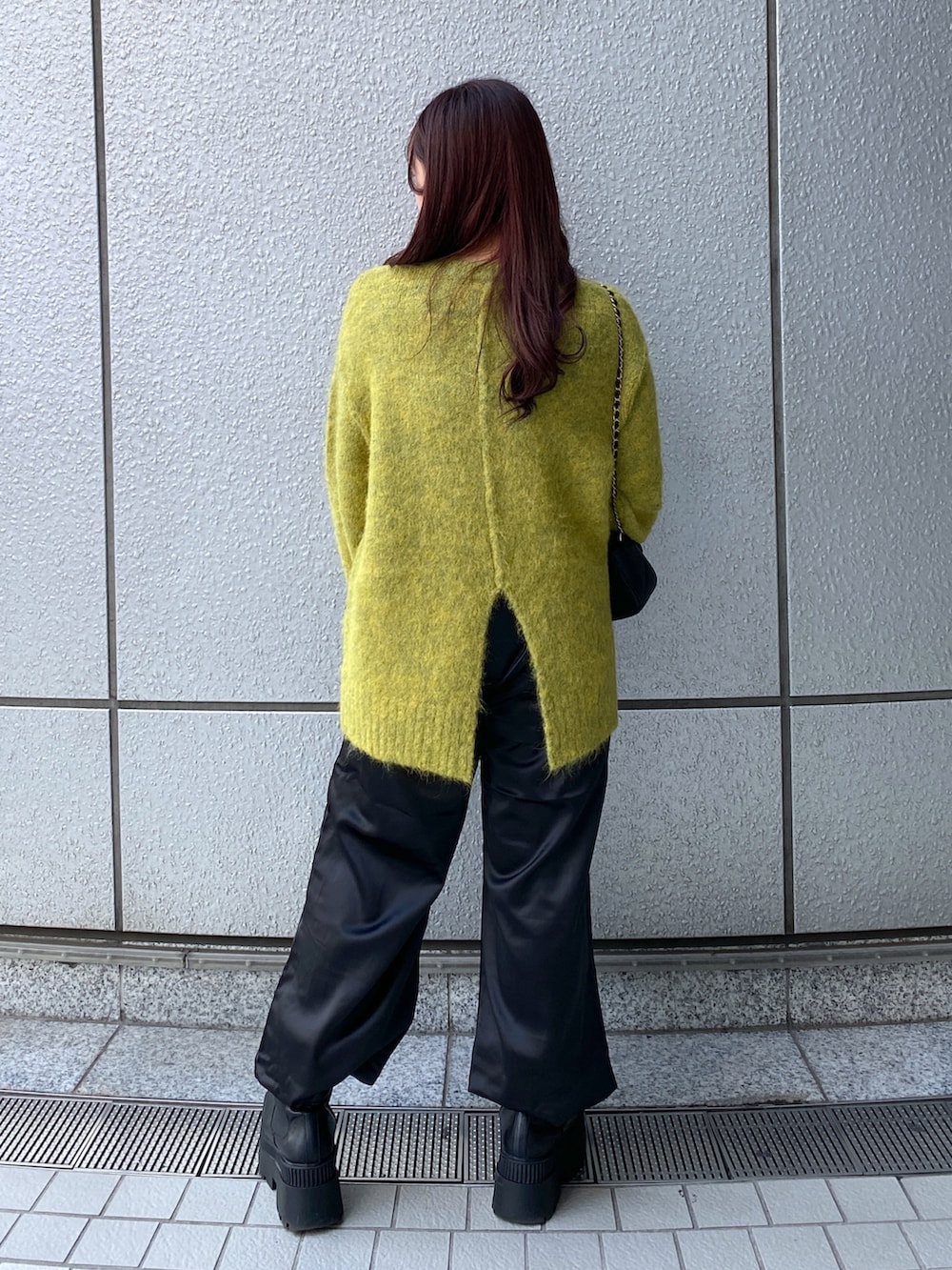 イエロー系のニット/セーター、ブラック系のショルダーバッグ、ブラック系のカーゴパンツを着用したレディースの秋コーディネートの2枚目の写真
