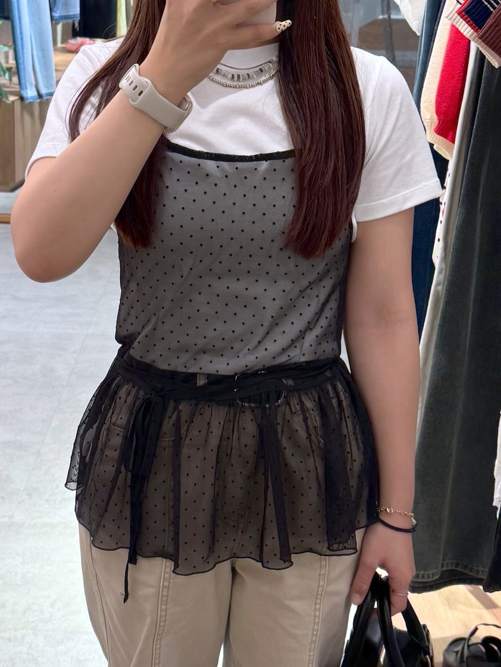 ベージュ系のデニムパンツ、ブラック系のパンプス、ブラック系のハンドバッグを着用したレディースの夏コーディネートの2枚目の写真