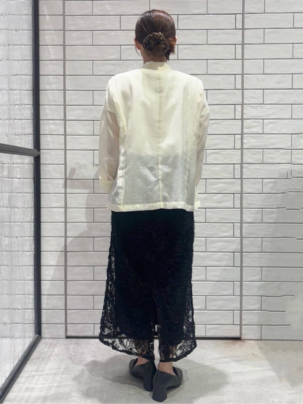 ホワイト系のテーラードジャケット、ホワイト系のTシャツ/カットソー、ブラック系のスカートを着用したレディースの春コーディネートの3枚目の写真
