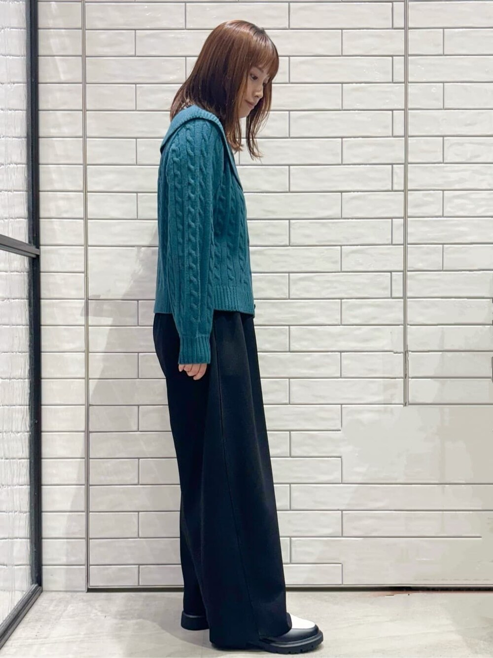 ブルー系のニット/セーター、ブラック系のその他パンツ、ブラック系のパンプスを着用したレディースの秋コーディネートの2枚目の写真