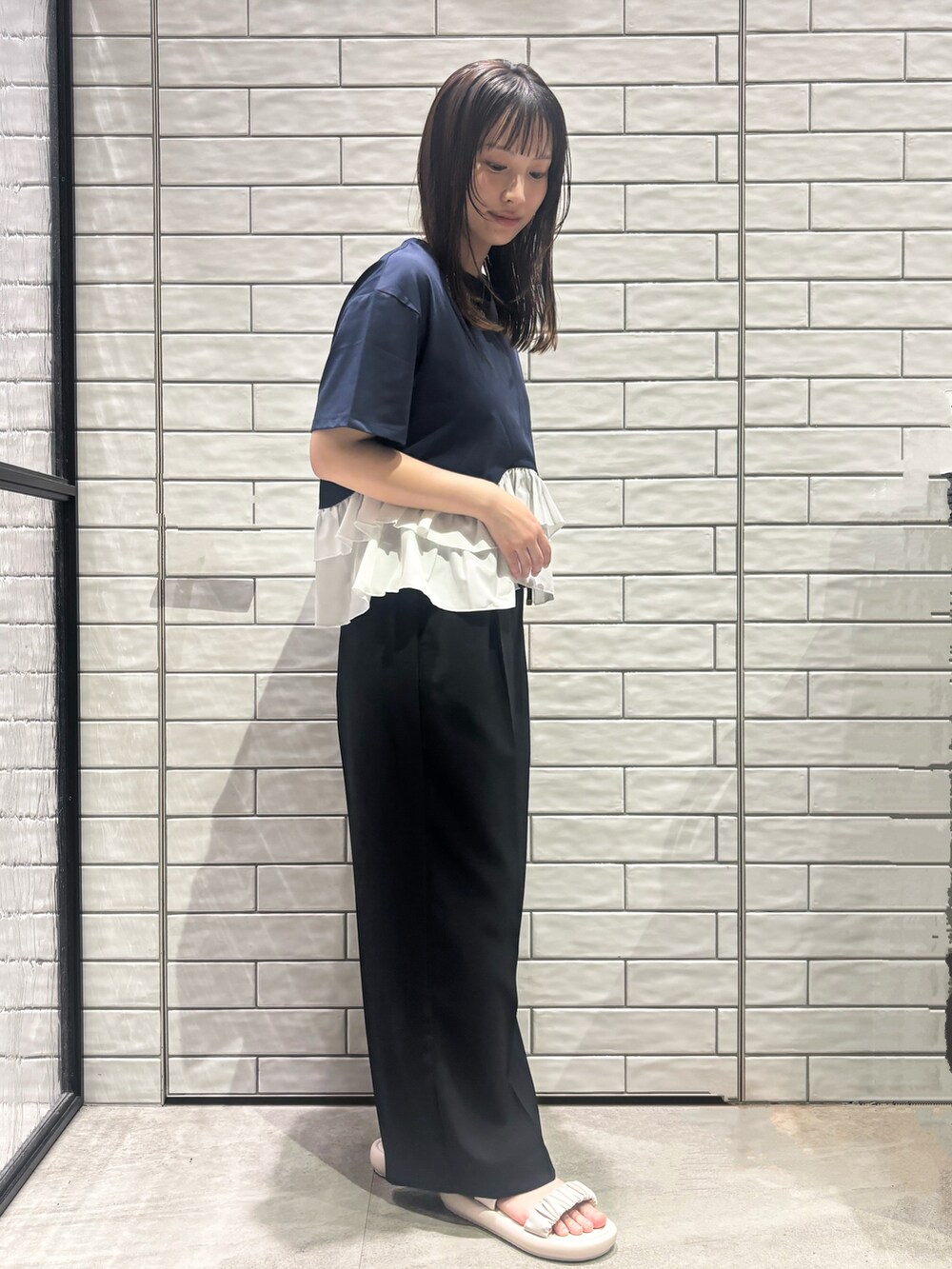 ブルー系のTシャツ/カットソー、ブラック系のその他パンツ、ホワイト系のサンダルを着用したレディースの春コーディネートの5枚目の写真