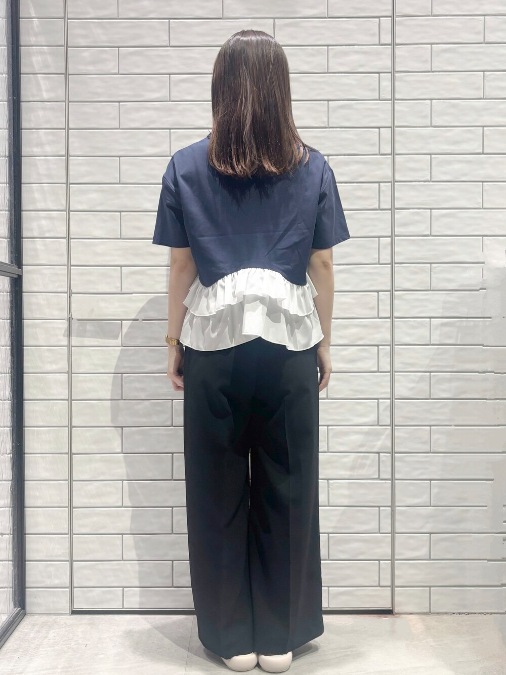 ブルー系のTシャツ/カットソー、ブラック系のその他パンツ、ホワイト系のサンダルを着用したレディースの春コーディネートの6枚目の写真