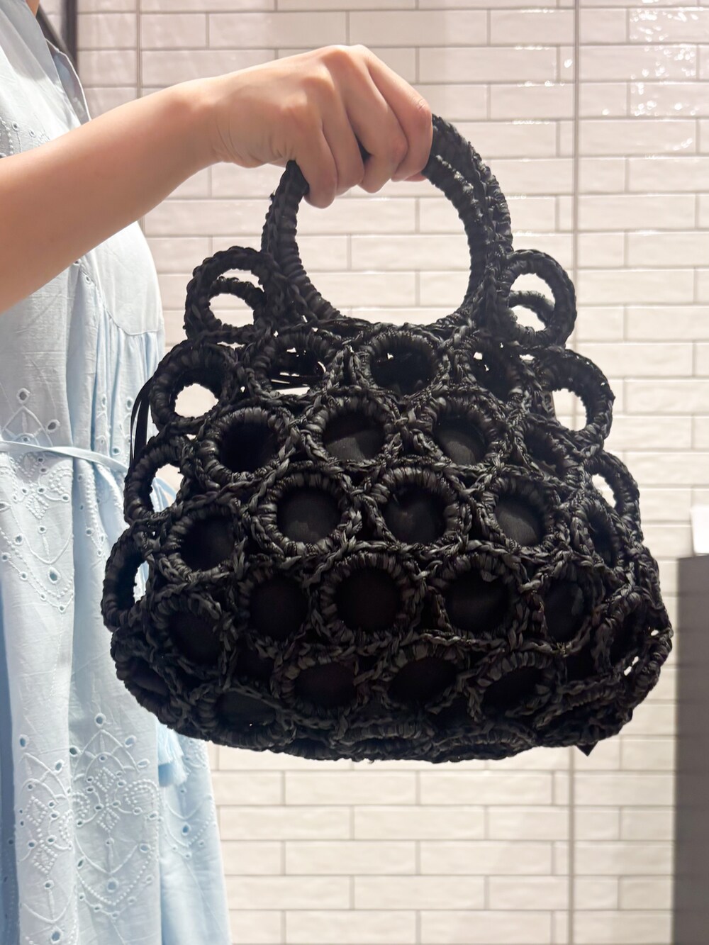 ブラック系のタンクトップ、ブルー系のワンピース、ホワイト系のハンドバッグを着用したレディースの夏コーディネートの8枚目の写真