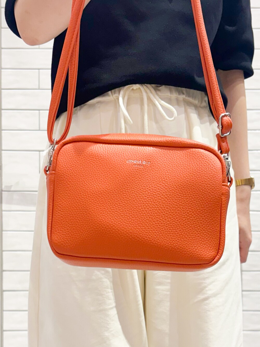 ブラック系のニット/セーター、ホワイト系のその他パンツ、ベージュ系のパンプスを着用したレディースの春コーディネートの4枚目の写真