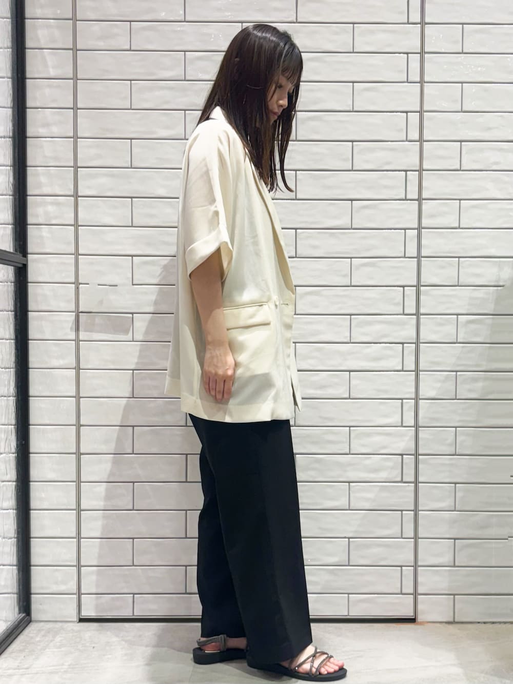 ブラック系のその他パンツ、シルバー系のサンダル、ホワイト系のテーラードジャケットを着用したレディースの春コーディネートの3枚目の写真