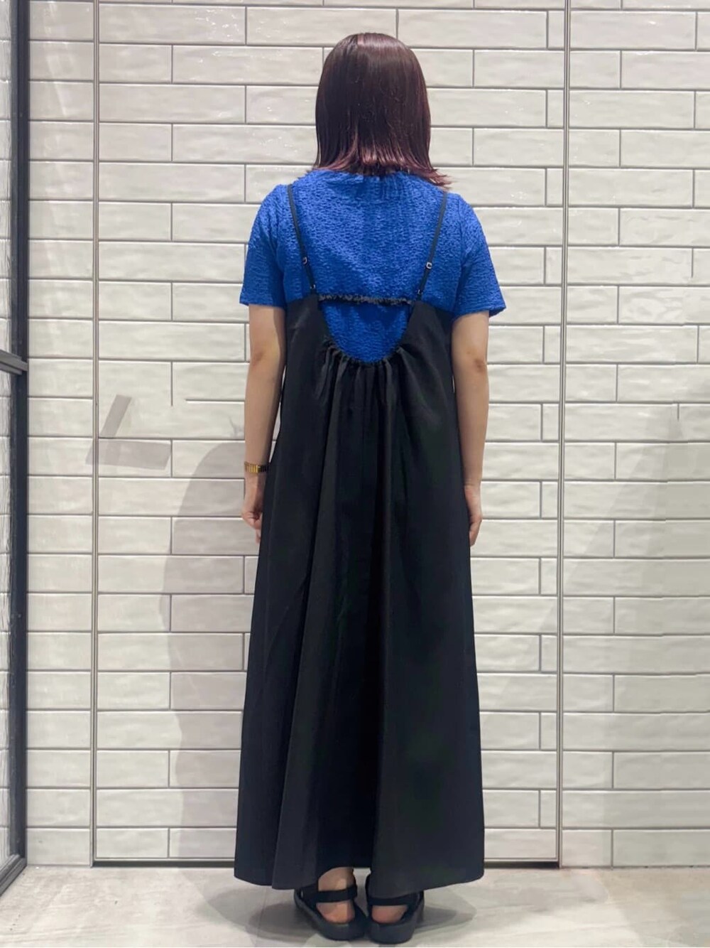 ブルー系のTシャツ/カットソー、ブラック系のワンピース、ベージュ系のショルダーバッグを着用したレディースの夏コーディネートの3枚目の写真