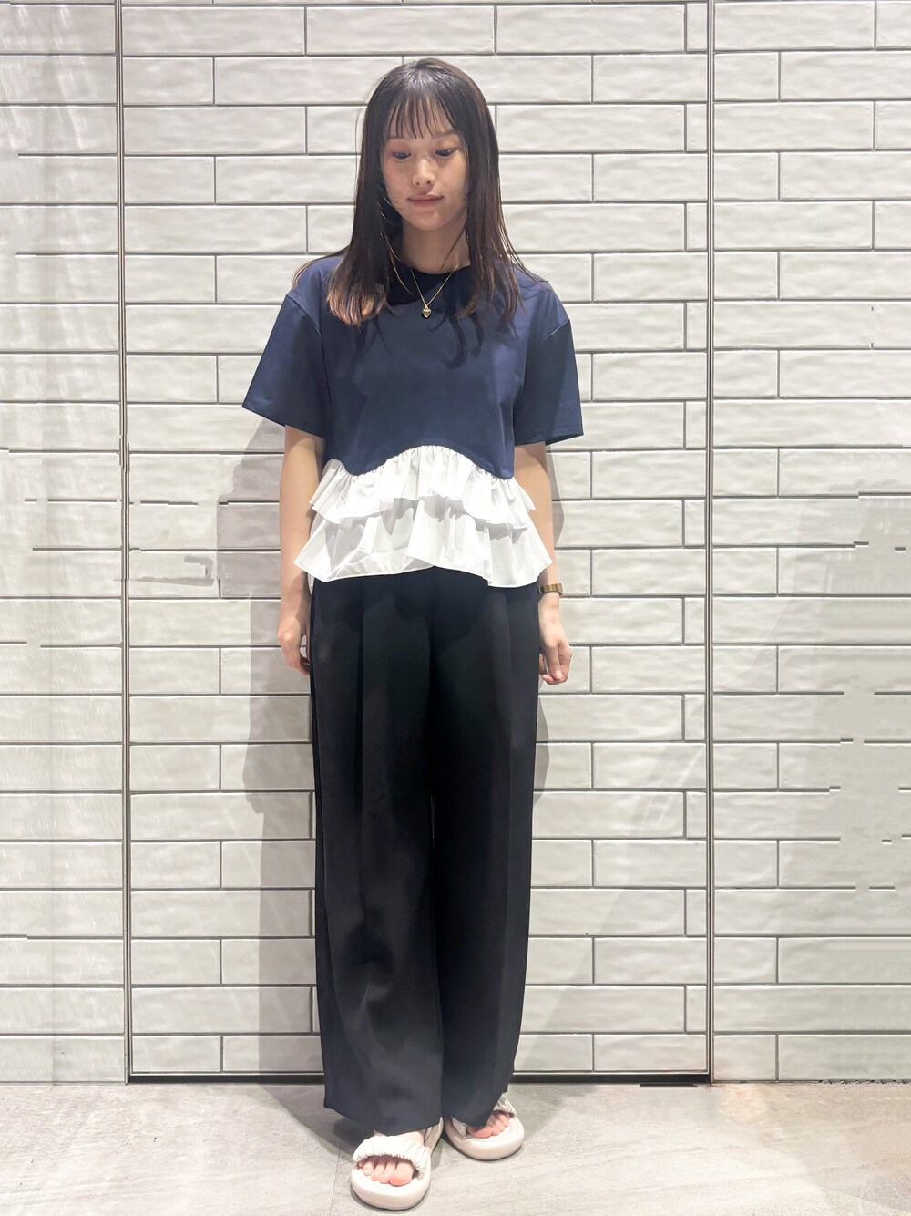 ブルー系のTシャツ/カットソー、ブラック系のその他パンツ、ホワイト系のサンダルを着用したレディースの春コーディネートの3枚目の写真