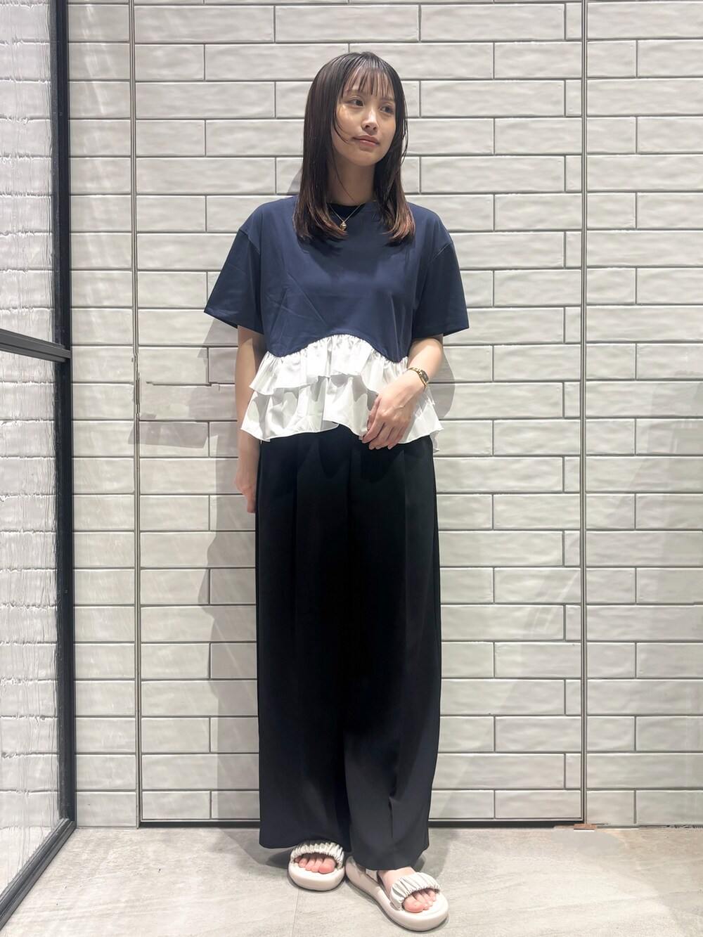 ブルー系のTシャツ/カットソー、ブラック系のその他パンツ、ホワイト系のサンダルを着用したレディースの春コーディネートの4枚目の写真