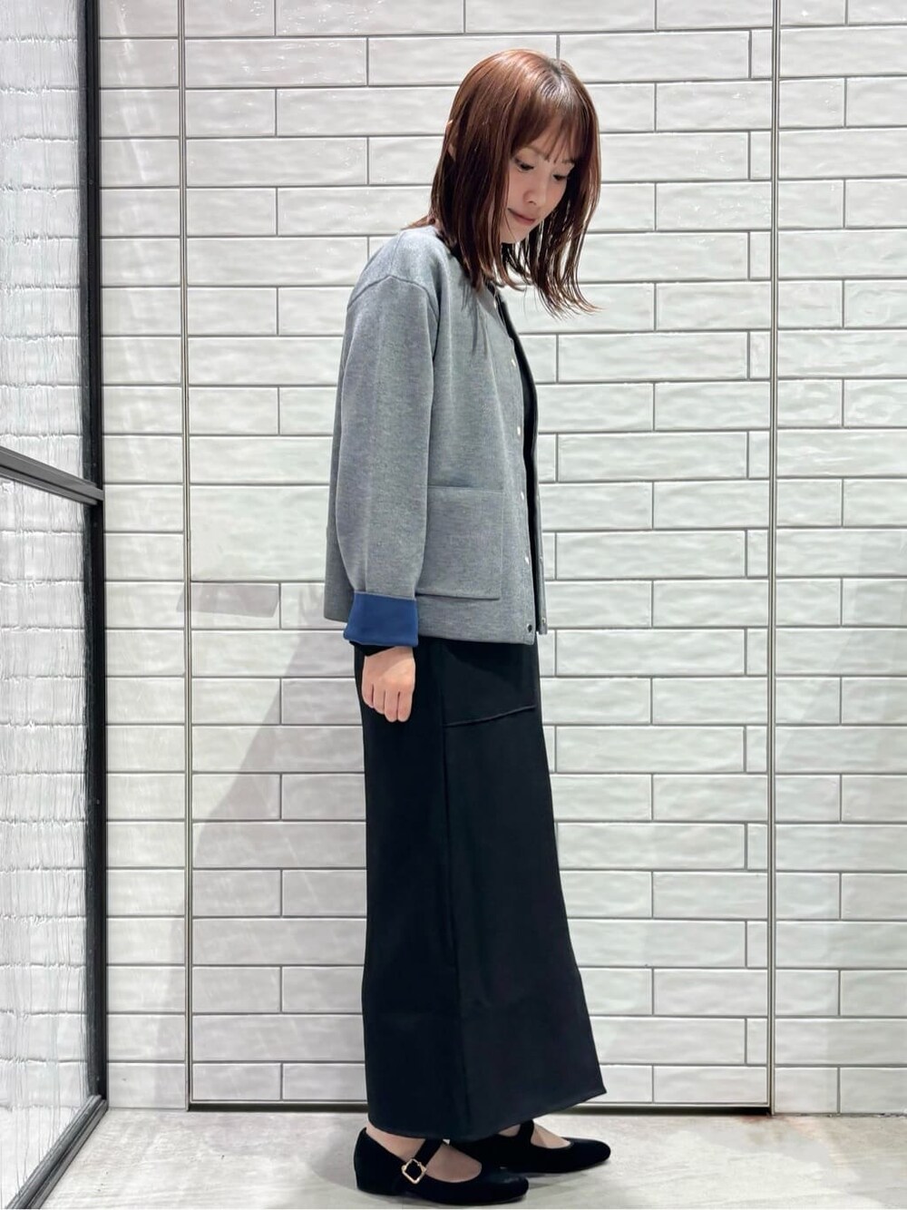 グレー系のカーディガン/ボレロ、ブラック系のTシャツ/カットソー、ブラック系のスカートを着用したレディースの秋コーディネートの3枚目の写真