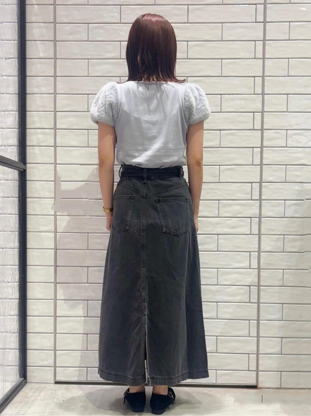 ブルー系のニット/セーター、ブラック系のデニムスカート、ブラック系のトートバッグを着用したレディースの夏コーディネートの3枚目の写真