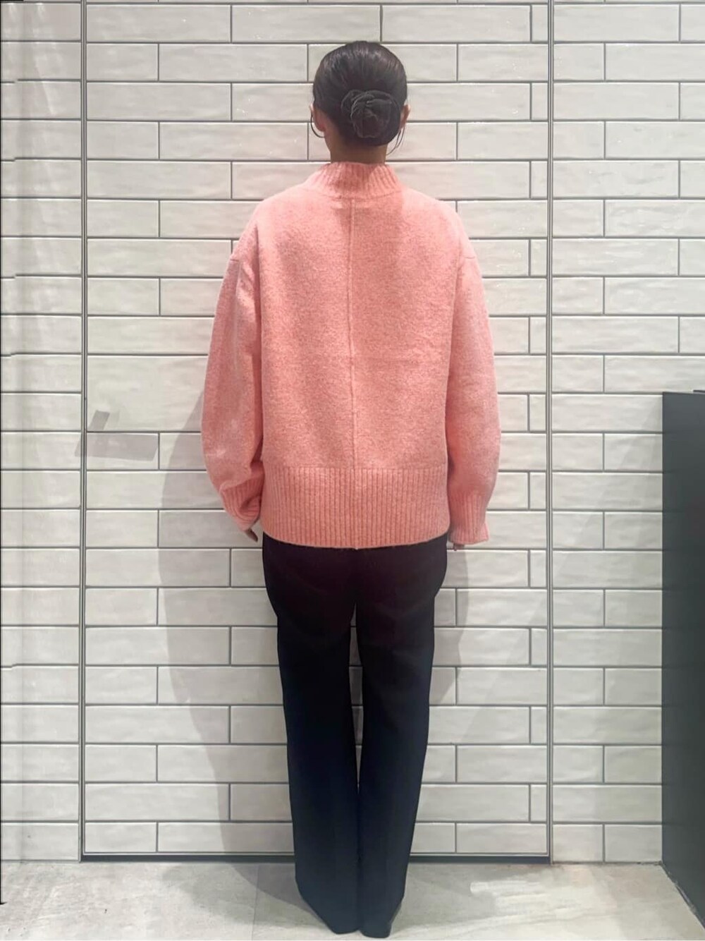 ピンク系のニット/セーター、ブラック系のその他パンツ、ブラウン系のショルダーバッグを着用したレディースの冬コーディネートの3枚目の写真
