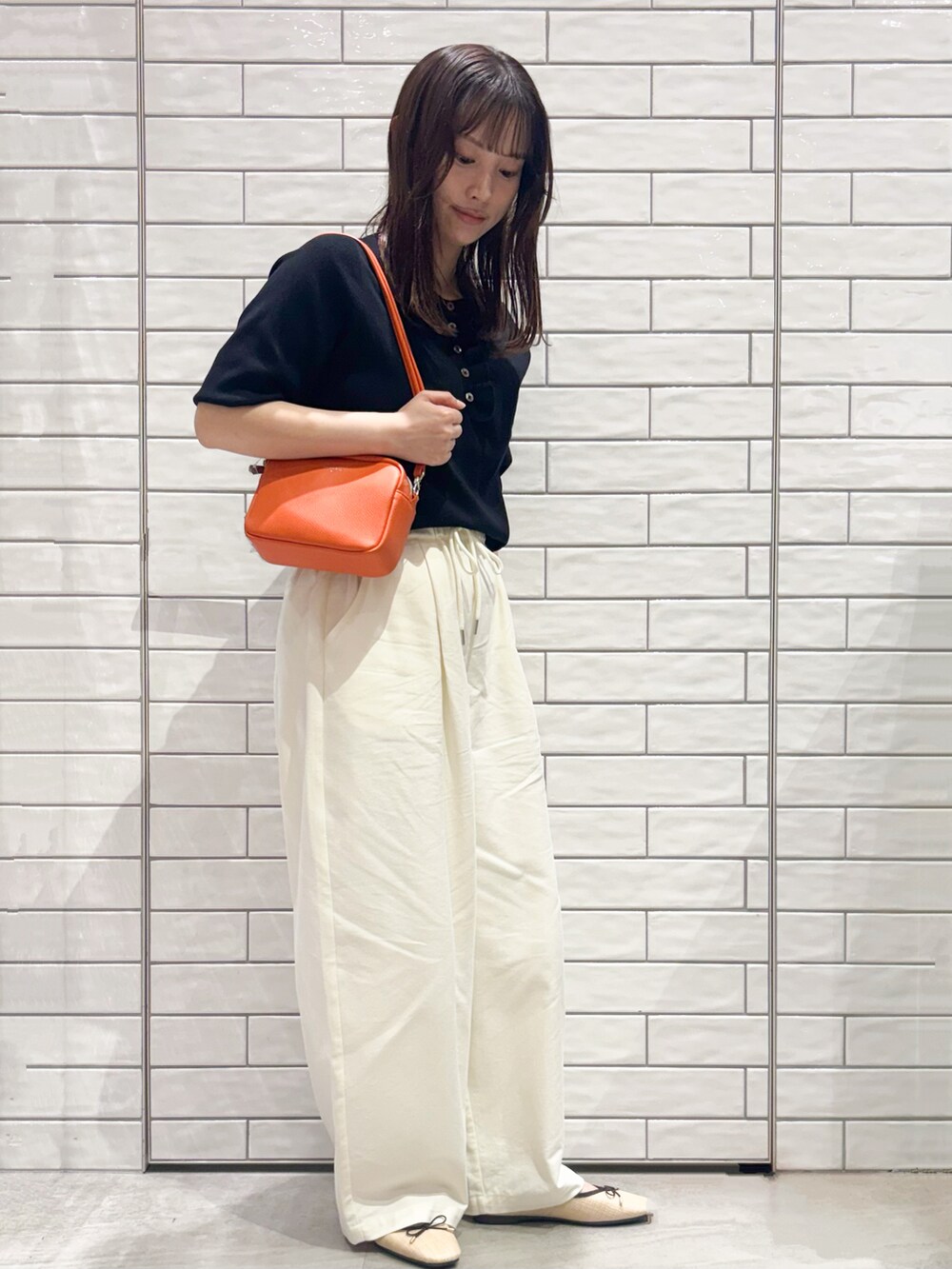 ブラック系のニット/セーター、ホワイト系のその他パンツ、ベージュ系のパンプスを着用したレディースの春コーディネートの3枚目の写真