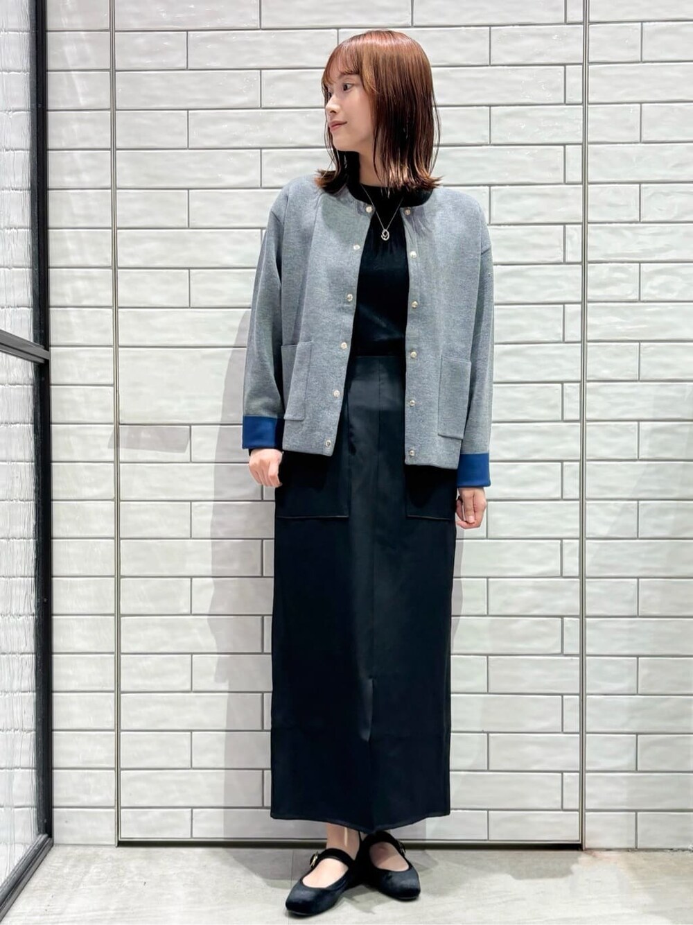 グレー系のカーディガン/ボレロ、ブラック系のTシャツ/カットソー、ブラック系のスカートを着用したレディースの秋コーディネートの2枚目の写真