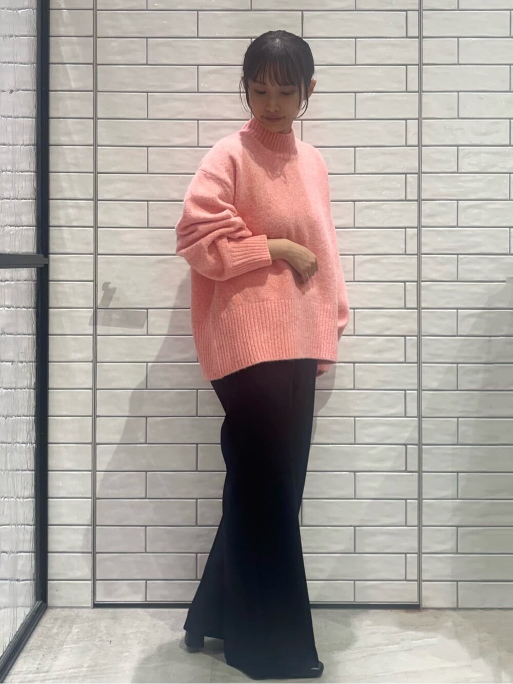 ピンク系のニット/セーター、ブラック系のその他パンツ、ブラウン系のショルダーバッグを着用したレディースの冬コーディネートの2枚目の写真