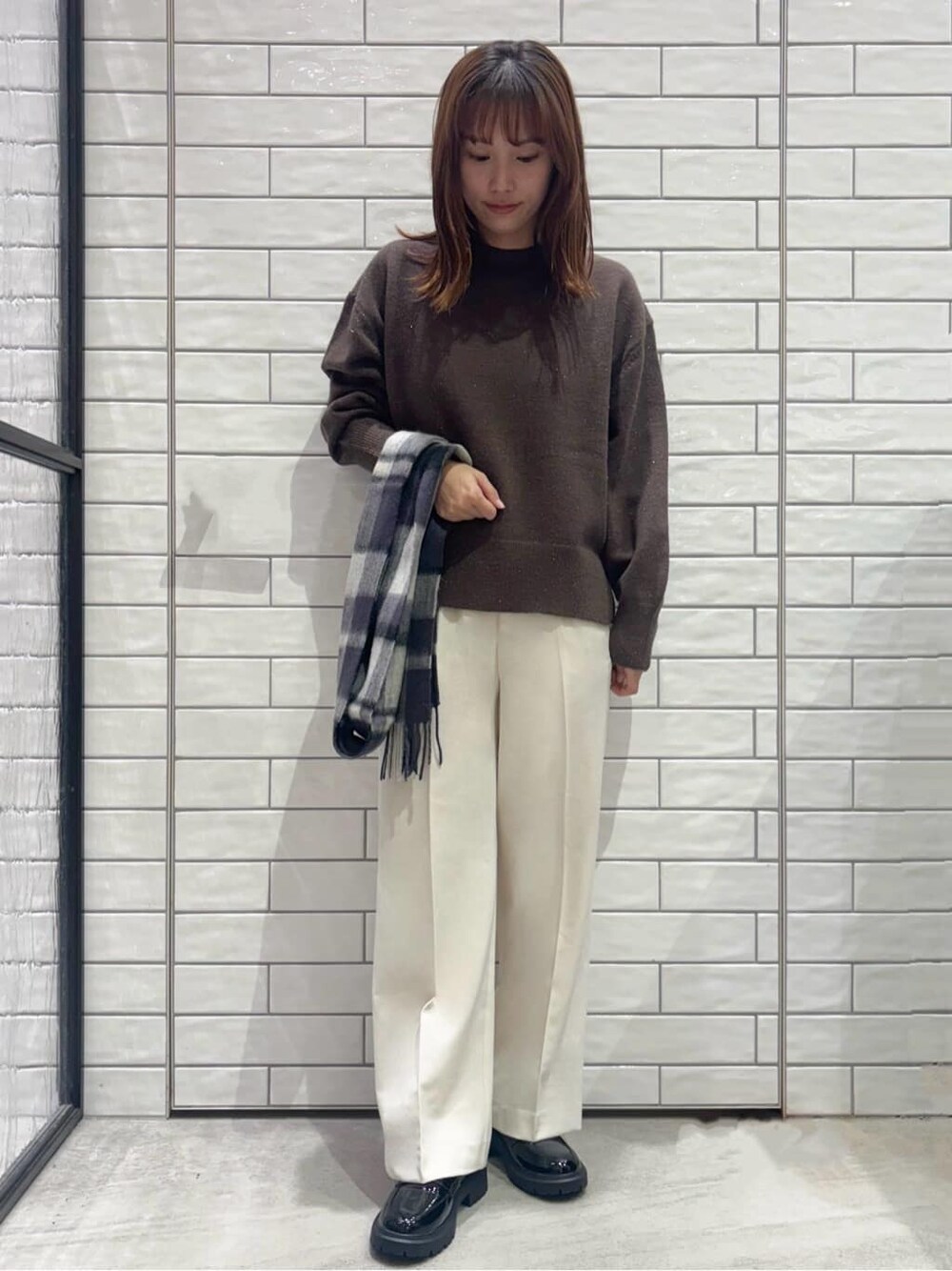 ブラウン系のニット/セーター、ホワイト系のその他パンツ、ブラック系のパンプスを着用したレディースの冬コーディネートの2枚目の写真