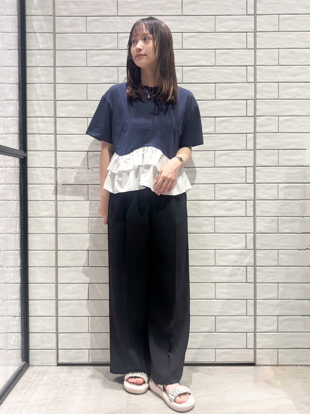 ブルー系のTシャツ/カットソー、ブラック系のその他パンツ、ホワイト系のサンダルを着用したレディースの春コーディネートの2枚目の写真